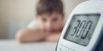 در پس زمینه یک بچه استرس دارد_یک بچه ترسیده_و در جلوی تصویر یک گلوکومتر بزرگ وجود دارد که عدد 300 را نشان می دهد